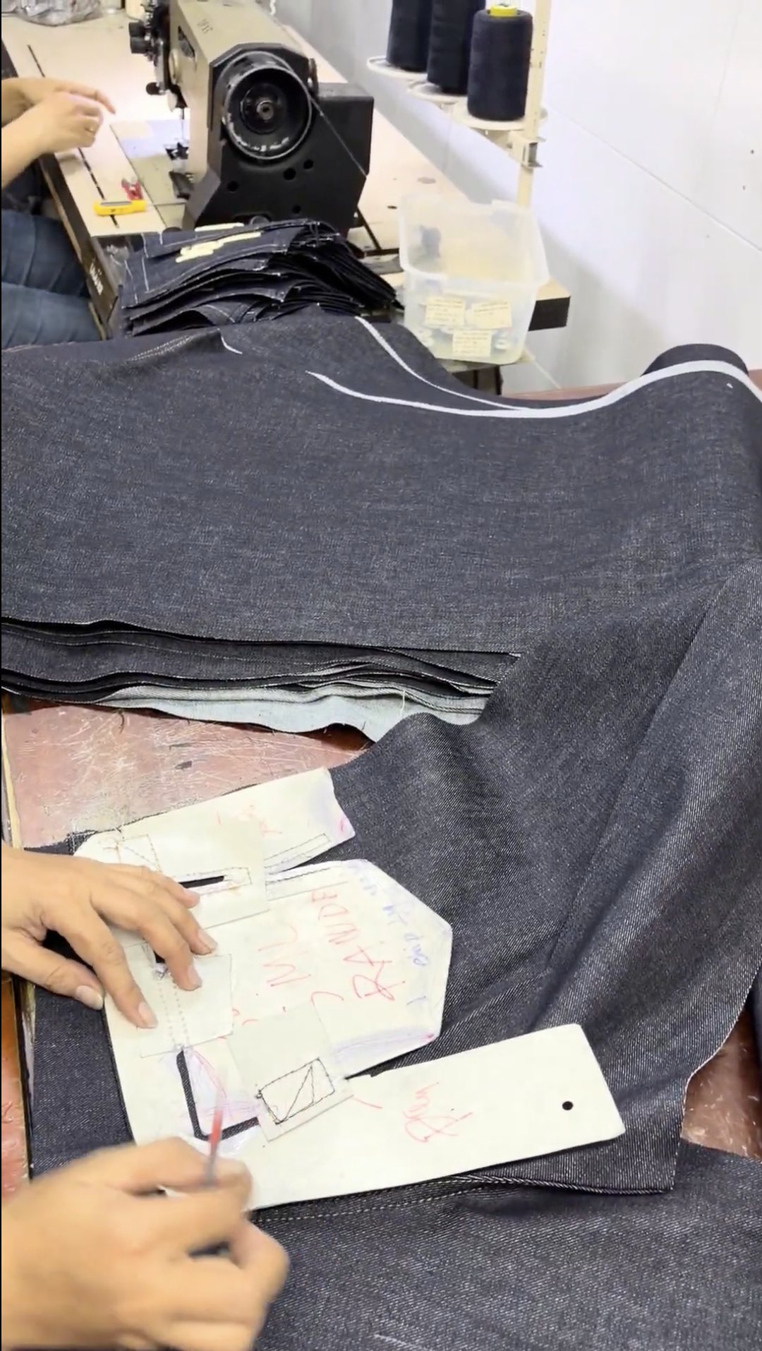 Marking a cut panel against a card pattern beside the sewing machine
